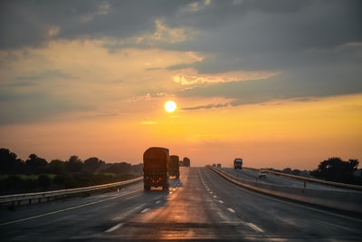 At sunset the red truck on the highway
